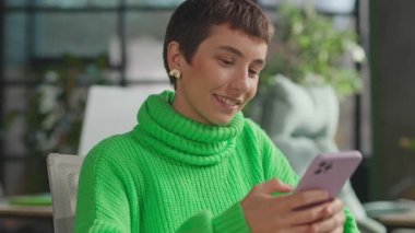 Pembe saçlı gülümseyen kadın LGBT çıkartmalı dizüstü bilgisayar kullanıyor. Ofis gecesinde mutlu oluyor.