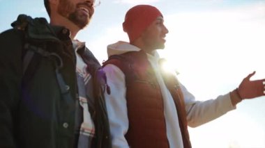 Ormanda nehir kenarında yürüyen turist kıyafetli neşeli eşcinsel çiftin portresi.