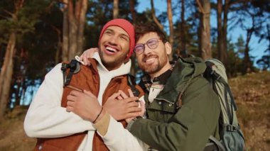 Spor giyimli eşcinsel çift güneşli bir günde orman turizminin tadını çıkarıyor.
