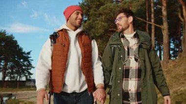 Tatil sırasında Forest Gölü 'nün yakınlarında yürüyen neşeli, çok ırklı eşcinsel bir çift.