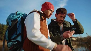 Tatilde gezen eşcinsel çift navigatörle akıllı telefonun ekranına dokunuyor.