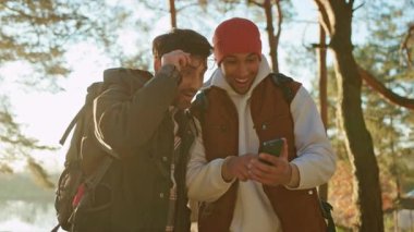 Sürpriz eşcinsel çift yürüyüş yapıyor ve turist yolculuğunda akıllı telefonlarda harita uygulaması kullanıyor.