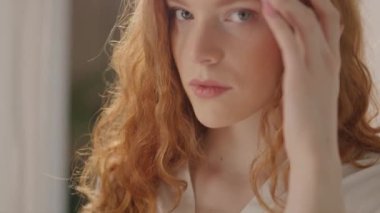 Gökkuşağı renkli küpeleri olan genç bir kadının yüzü kamera tebessümlerine bakar. LGBT