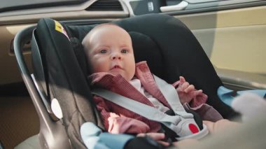 Duygularını kapat, sevimli küçük kız bebek arabasının koltuğunda otururken mutlu oluyor. Çocuk arabanın içindedir. Araç ve ulaşım konsepti. Seyahat et. Yavaş çekim