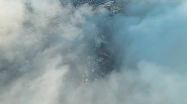 Şehrin üzerinde hareket eden güçlü beyaz bulutların hava kuşbakışı drone görüntüsü. Muhteşem panoramik şehir manzarası. Helikopter uçuşu. Bulut manzarası.