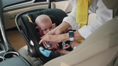 Kemerleri bağlayan genç beyaz bir kadının elleri vurularak. Annem seyahat sırasında sevimli oğluna bakıyor. Hafta sonu. Nakliye, araç, otomobil. Ebeveynlik, çocuk