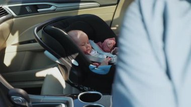 Babamın yanında bebek koltuğunda oturan sevimli bebeğin yatay görüntüsü. Komik küçük bir çocuk. Güvenlik koltuğu. Yolculuk için hazırlık çocuğu. Hafta sonu, ebeveynlik