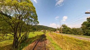 Yeşillik, demiryolu ve dolambaçlı bir yoldan oluşan çarpıcı ve güzel bir kırsal alan.