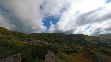 Bulutlu gökyüzü. Tepeden tırnağa dağın zirvesine giden hava manzarası. Ukrayna Karpatı. Yeşil Orman