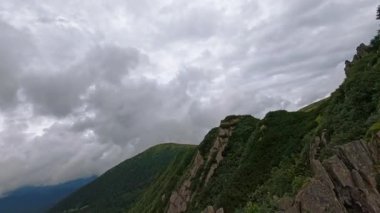 Görkemli dağların ve yemyeşil vadilerin nefes kesici ve büyüleyici manzarası dramatik bulut örtüsünün altında yatıyor.