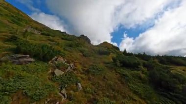 Kesinlikle göz kamaştırıcı dağ manzaraları sergiler yemyeşil yemyeşil yukarıdaki dinamik bulut oluşumlarıyla tamamlanır