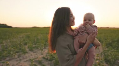 Anne, kızıyla birlikte bir ayçiçeği tarlasında duruyor. Mutlu aile ve yardım eli kavramı. Çocuk koruması.
