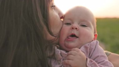 Annesi tarlada dururken mutlu bir çocuk. Çocuk ve ebeveyn doğada oynarlar. Mutlu aile ve çocukluk kavramı.