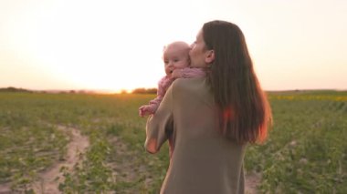 Çekici genç bir kadının güzel bir kızı ellerinin arasında tuttuğu bir sahne. Anne Wirh çocuk şehir dışına doğru yürüyor. Akşam vakti, gün batımı. Açık hava.