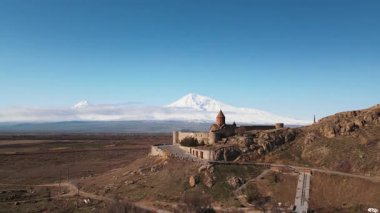 Muhteşem manzarada hava aracı uçuşu. Issız kayalık arazi, dağ arkası ve tarihi kilise. Meşhur dönek manastırı. Ermenistan seyahati.