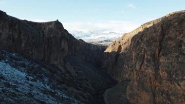 Kafkasya, Ermenistan. Dağlarda güneşli, güzel bir gün. Mavi gökyüzü altında kayaları kaplayan vahşi büyük kar. Seyahat yerleri. Hava aracı uçuşu.