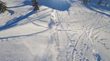 Dağlardaki insansız hava aracı görüntüsü, kar motosikletli bir adam kışın güneş ışığında atlar ve ata biner. Güneşli bir günde