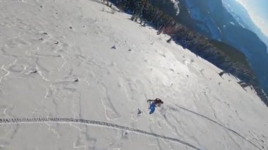 Dağlardaki hava manzaralı, kar motosikletli iki adam kışın güneş ışığında atlayıp gezerler. Güzel manzara