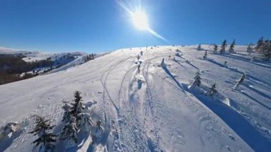 Dağ manzaralı, kar motosikletli bir adam kışın güneş ışığında atlar ve ata biner. Güzel manzara