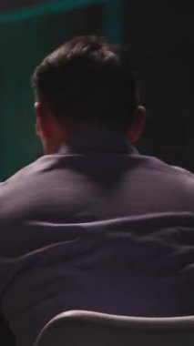 Gözlüklü ve mor tişörtlü neşeli bir adam akıllı telefonundan zevk alıyor. Ekrana odaklanırken tatmin olmuş bir şekilde gülümsüyor. Teknolojiyi neşeyle harmanlıyor.