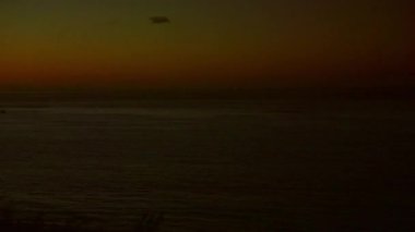 Okyanusun üzerinde gün batımını bir uçak ve renkli bir gökyüzünde sıcak hava balonuyla yaşayın. Sakin sular altın güneşi yansıtıyor, huzuru çağrıştırıyor.