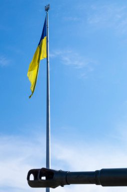 Eski askeri silah grupları Ukrayna bayrağının arka planına karşı. Topçu silahının namlu freni. Güneşli sabah gökyüzü. Şiddet kavramını durdurmak için ara. Ukrayna bayrağı