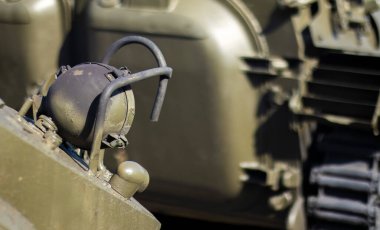 Savaş tankı korumalı ön far. Tank taretinde çok parlak bir projektör, yakın plan. Zırhlı piyade savaş aracı. Eski bir zırhlı personel taşıyıcısının parçası, haki rengi far.