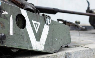 Ukrayna 'da savaş. Üzerinde V harfi olan parçalanmış bir kule ile parçalanmış bir tank. Kırılmış ve yanmış Rus tankları. Tankın üzerinde beyaz boya işareti ya da sembolü var. Harap edilmiş askeri ekipman
