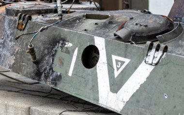 Ukrayna 'da savaş. Üzerinde V harfi olan parçalanmış bir kule ile parçalanmış bir tank. Kırılmış ve yanmış Rus tankları. Tankın üzerinde beyaz boya işareti ya da sembolü var. Harap edilmiş askeri ekipman