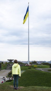 Ukrayna 'nın bayrağına bayrak direğinde duran küçük bir kız. Ukraynalılar savaşa karşıdır. Ukrayna 'daki askeri operasyonlara dikkat çekiyor. Ukrayna, Kyiv - 9 Ekim 2022