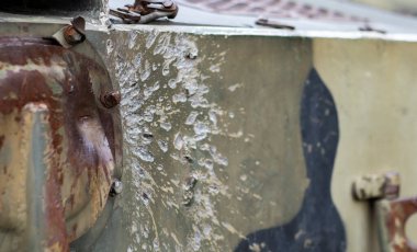 Zırhında delikler olan Rus savaş aracı. Yok edilmiş askeri zırhlı araçlar, devre dışı bırakılmış, havaya uçurulmuş ve yok edilmiş. Kurşun delikli zırhlı metal arka plan. Kümülatif delikten delik