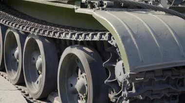 Yeşil bir tankın tırtılları ve silindirleri. Ordu konsepti. Kamera hareketlerini kapat. Tırtıl tekerlekleri. Yaklaş.
