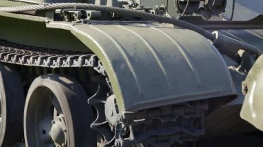 Yeşil bir tankın tırtılları ve silindirleri. Ordu konsepti. Kamera hareketlerini kapat. Tırtıl tekerlekleri. Yaklaş.