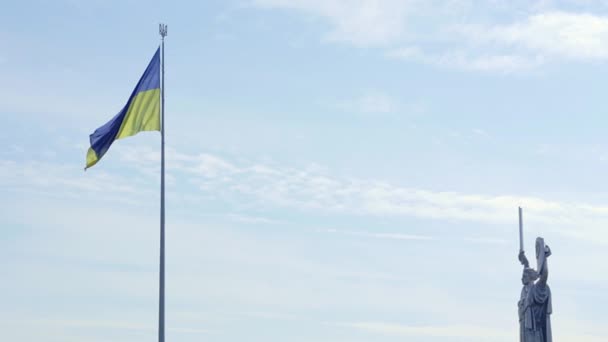 Bandeira Ucraniana Agitando Vento Contra Céu Azul Perto Famosa Estátua — Vídeo de Stock