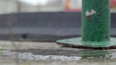 Falling water drop. Use of water resources. Splashes of water. Drops falling from the tap on the street in slow motion. Daylight, close-up. Selective focus