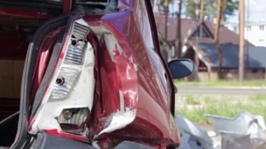 Red car after a terrible accident on the side of the road. Frontal and side impact. Life insurance. An accident without the possibility of recovery. Back view. Damage after an accident