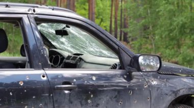 Bullet hole in a car door. Abandoned car with bullet holes. A destroyed vehicle in a war zone in Ukraine. Damaged civilian car. The car was damaged by shrapnel as a result of hostilities