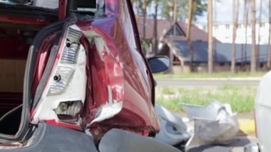 Red car after a terrible accident on the side of the road. Frontal and side impact. Life insurance. An accident without the possibility of recovery. Back view. Damage after an accident