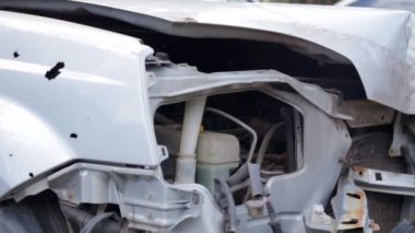 Çarpışma sonucu kırık farlar var. Kazadan sonra kırık gri bir araba. Araba kazası konsepti. Hasarlı acil durum farları, kaput ve tampon. Kazadan sonra cesette hasar var.