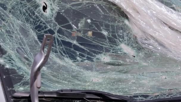 汽车的挡风玻璃上有个洞 是被火器击中的 子弹孔 粉碎汽车挡风玻璃 破碎和损坏的汽车 子弹在玻璃上打了一个破洞 — 图库视频影像