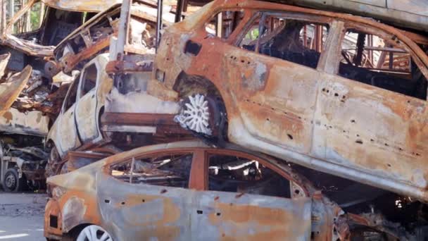 火后有车燃烧的汽车的铁零件 被烧毁的汽车被遗弃在一个安静的乡村边 火灾的结果 汽车保险的概念 俄罗斯对乌克兰的战争 — 图库视频影像