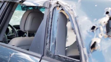 Car riddled with bullets. War of Russia against Ukraine. A car of civilians shot during the evacuation of women and children. Bullet holes and shell fragments. Cars destroyed by shell fragments