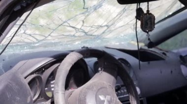 The wreckage of the interior of a modern car after an accident. Car interior after an accident with a cracked and broken windshield. Inside the car after a car accident. Ukraine, Irpin - May 12, 2022
