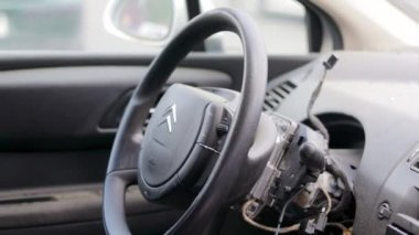 Closeup of the steering wheel of a car after the accident. The drivers airbags did not deploy. Broken windshield with steering wheel. Car interior. Black dashboard. Ukraine, Irpin - May 12, 2022