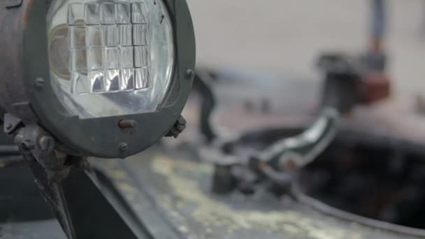 ソ連の戦車の正面ヘッドライト タンクタレット クローズアップで非常に明るいサーチライト 装甲歩兵戦闘車両 古い装甲人員キャリア カーキヘッドライトの断片 — ストック動画