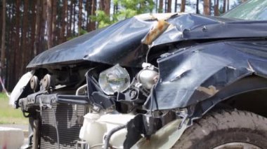 Black car after a terrible accident on the side of the road. Frontal and side impact. Life insurance. An accident without the possibility of recovery. Side view. Damage after an accident