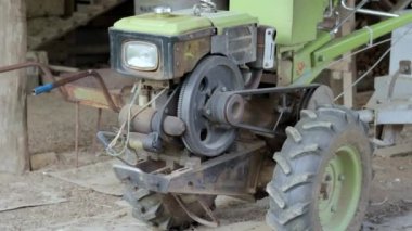 Karavanı olan tipik ağır dizel bir traktör. Kırsal kesimin tarım taşıma ekipmanları. Taşınabilir tarım ekipmanları, yürüyen minitractor. Başlangıç sistemi mekanik ve manüel.