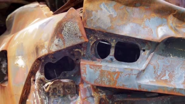 汽车被大火完全烧毁了 被遗弃的 烧毁的和生锈的汽车停在路边 汽车在停车场失火了 烧焦的尸体上有弹片和弹孔 火灾后的汽车 — 图库视频影像