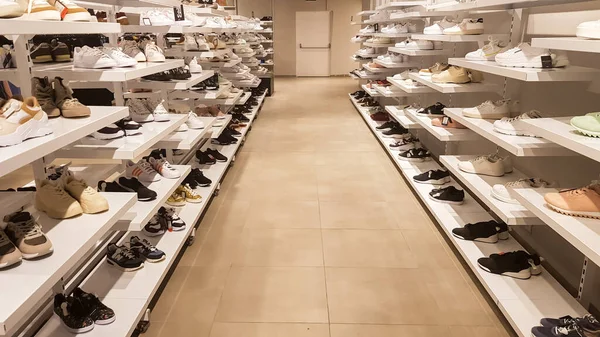 異なる靴の大規模なコレクション 男性用 女性用 子供用の靴をお探しですか 店内の棚に靴を履いたままの背景 靴の非常に大規模な選択 ストック写真