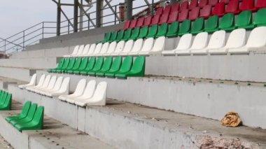 Ukrayna 'da savaş. Bir çocuk futbol okulundaki yıkılmış bir futbol stadyumunda, podyumdaki taraftarlar için kırık plastik banklar. Topçu ateşinin sonuçları..